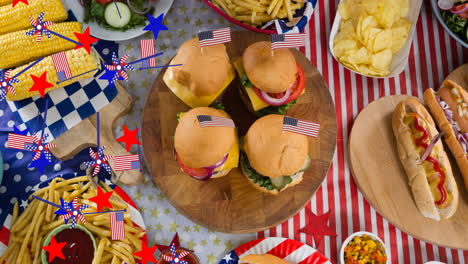 animation of stars and american flags over table with different food