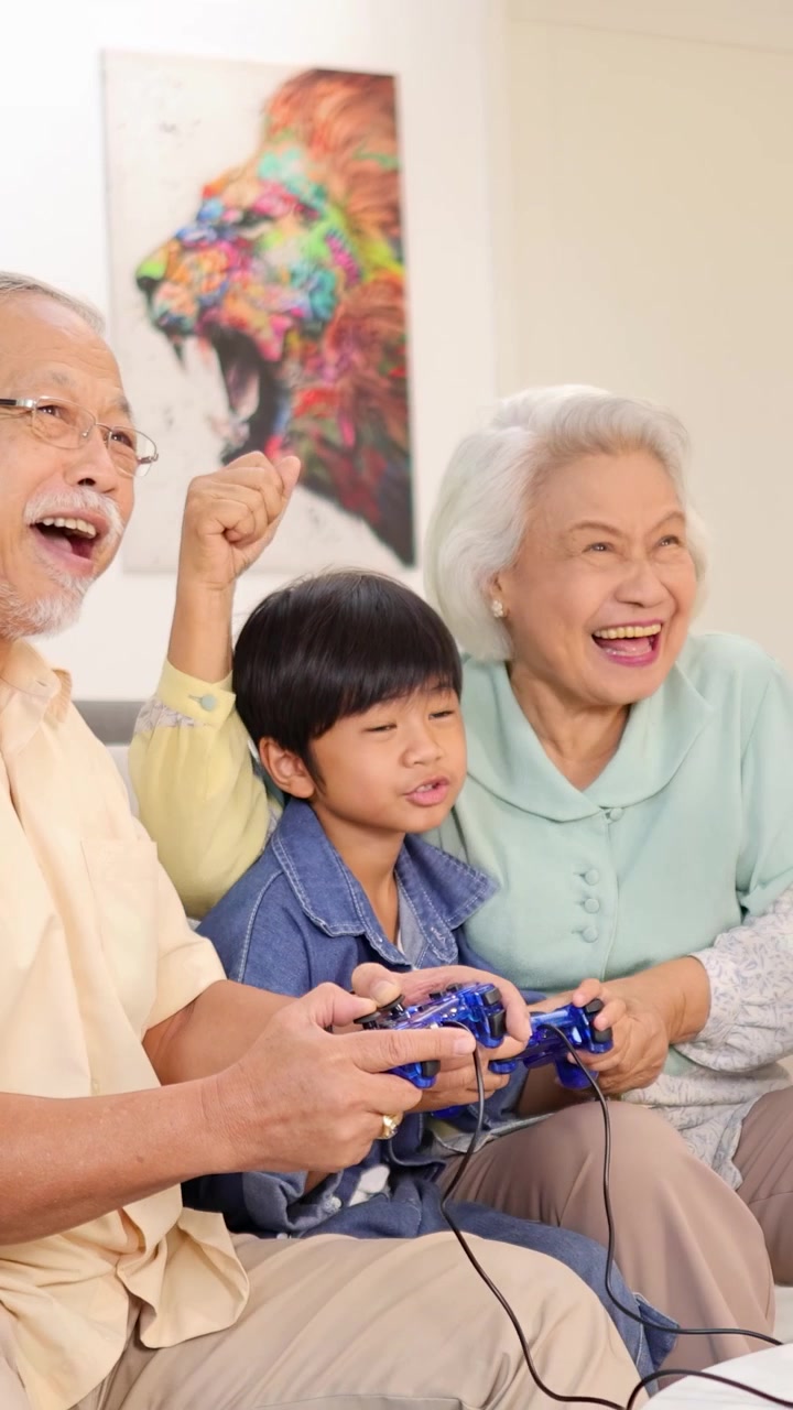 祖父母と孫が明るいリビングルームで一緒にビデオゲームを楽しみ、楽しいひとときを過ごしている。