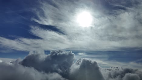 an immersive aerial cloudscape through the pilot’s eyes from a jet cockpit, flying over cottony clouds with a shinig sun veiled by ethereal cirrus clouds.