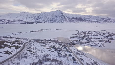 aerial follow of a truck on a road in lofoten islands, norway, during winter