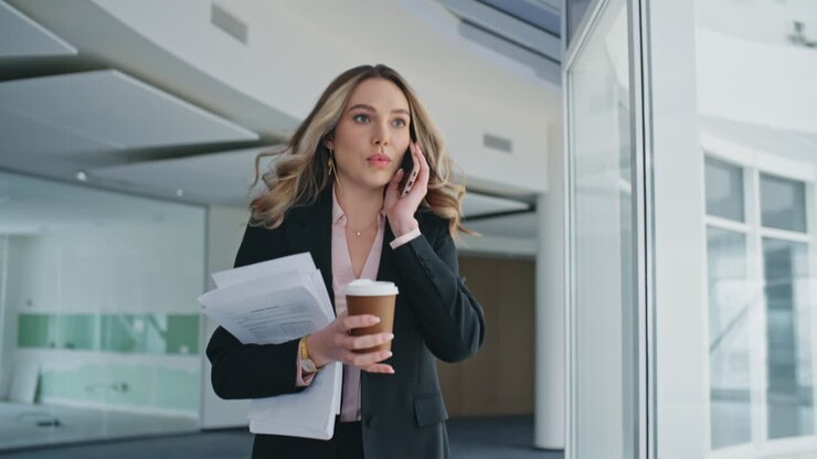 Busy woman going office hallway closeup. Late manager answering mobile phone