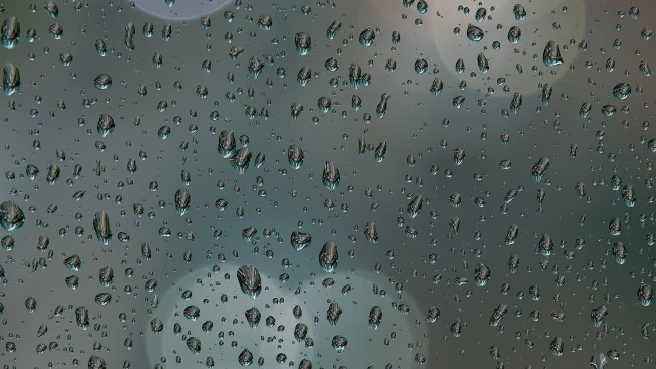 비가 오는 밤에 거리 조명과 자동차의 보케, 창문에 비방울.