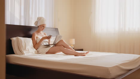 mujer trabajando en la computadora portátil en la cama