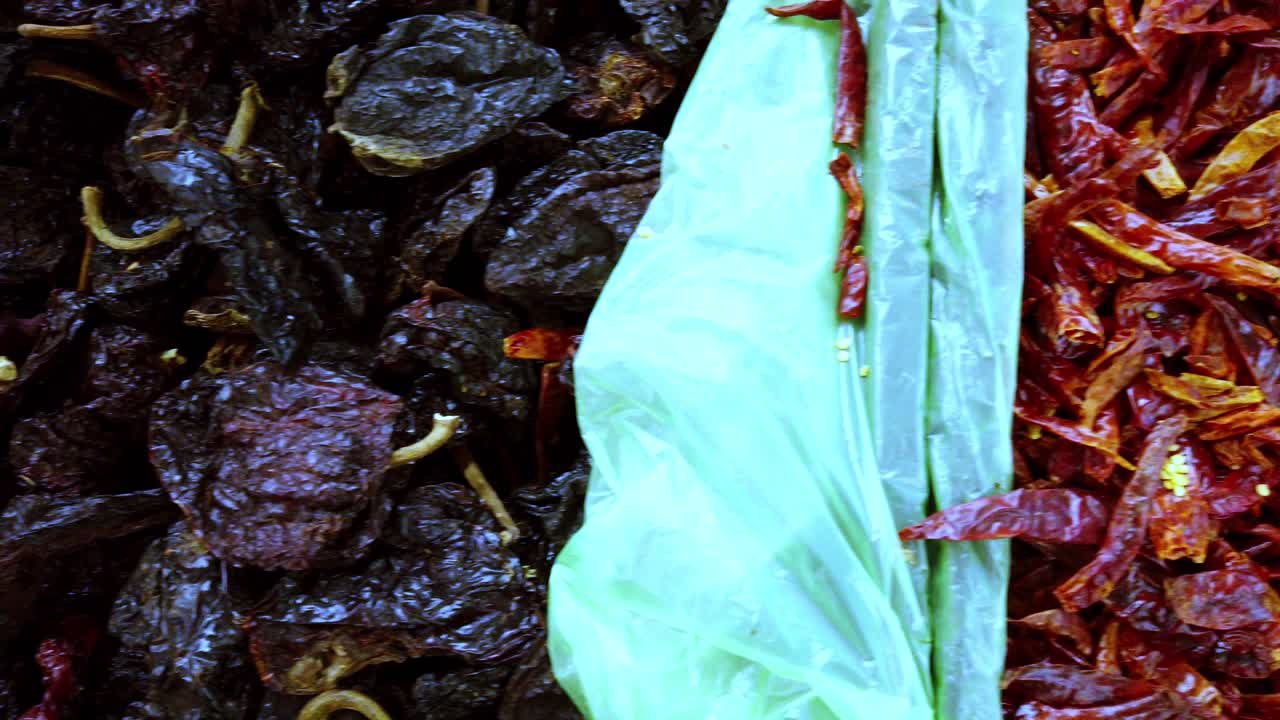 Close up shot of crushed guajillo chili in a big basket during the day, pan shot