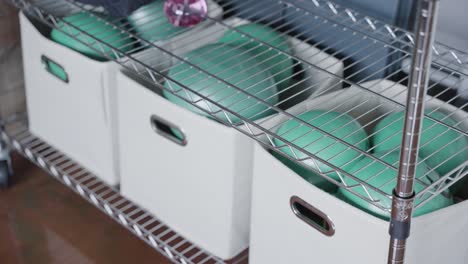 the gym's shelves are organized with neatly stacked boxes containing exercise balls