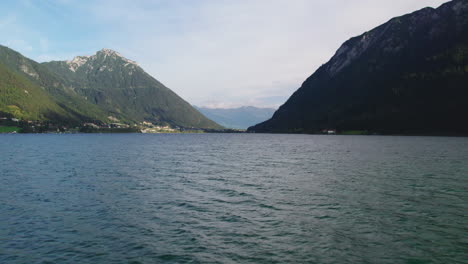 aerial view flying low across idyllic achen lake in achen valley, pertisau