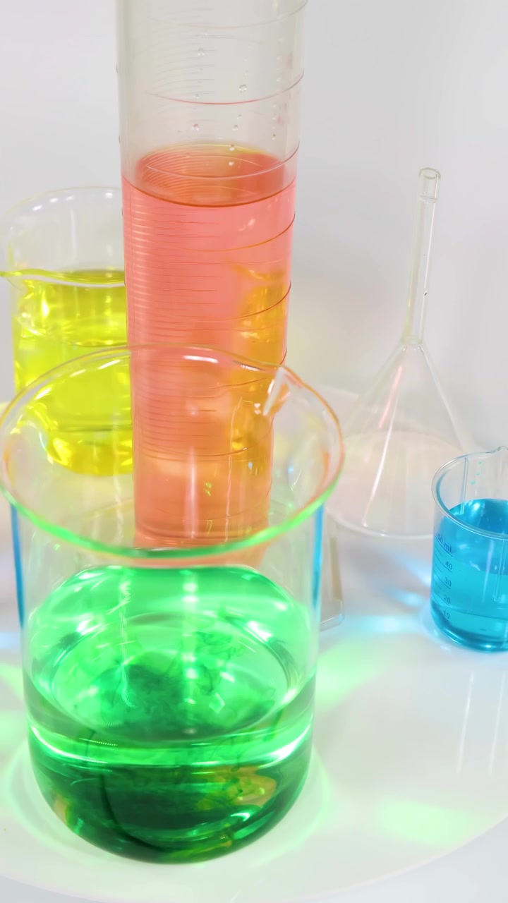 Liquidi di vari colori in becher e cilindri