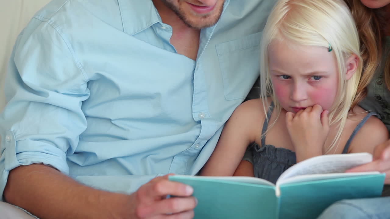 padres leyendo un libro con su hija