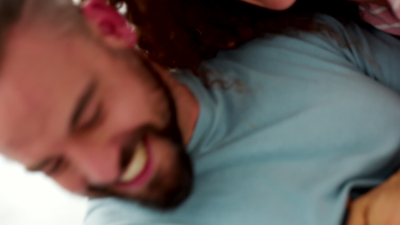 feliz, juguetona y pareja cosquilleando en un dormitorio