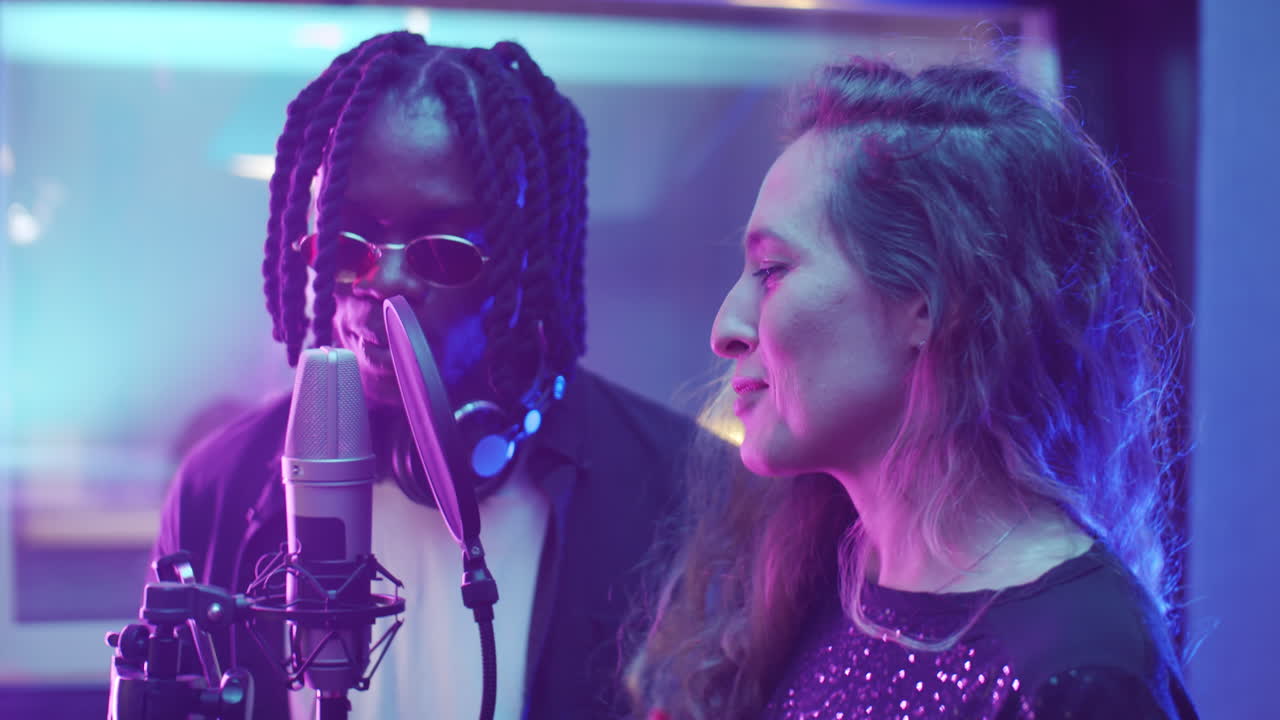 스튜디오에서 노래를 녹음하는 다민족 남녀