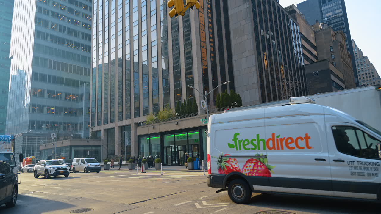 New York, USA, 28 December 2025: Midtown Manhattan Day Traffic. Vehicles pass through a Midtown Manhattan intersection with office towers and busy daytime city life