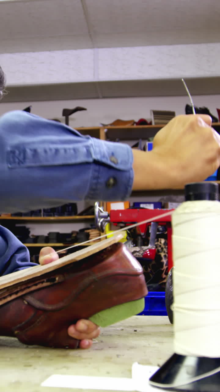 Cobbler stitching a shoe sole with needle
