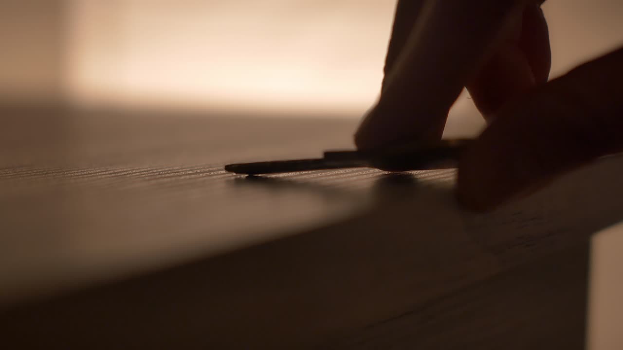 Macro shot of small gold key being taken off a grey desk