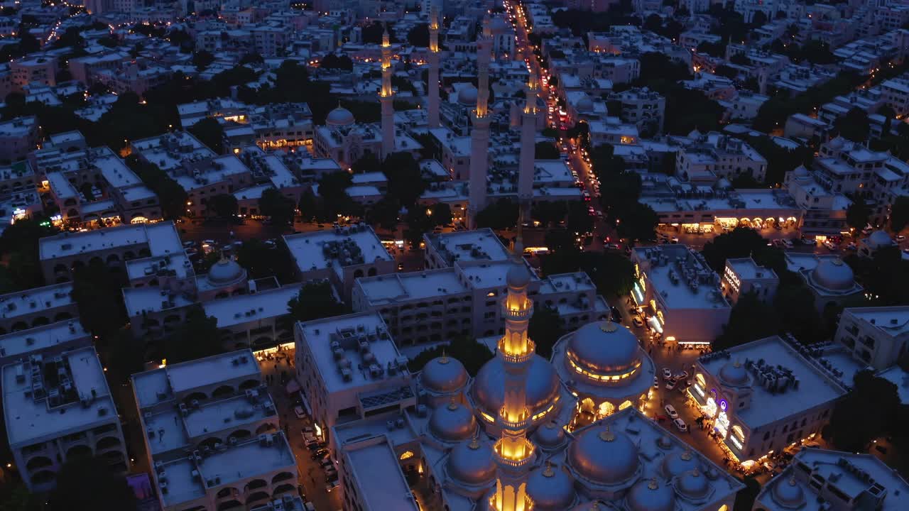Golden light bathing mosque's minaret and domes during Ramadan, revealing urban landscape's serene glow at twilight with peaceful architectural harmony