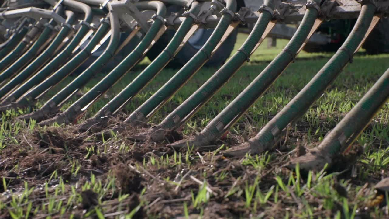 распространитель жидкого навоза, высвобождающий грязь на поле, близкий снимок медленного движения