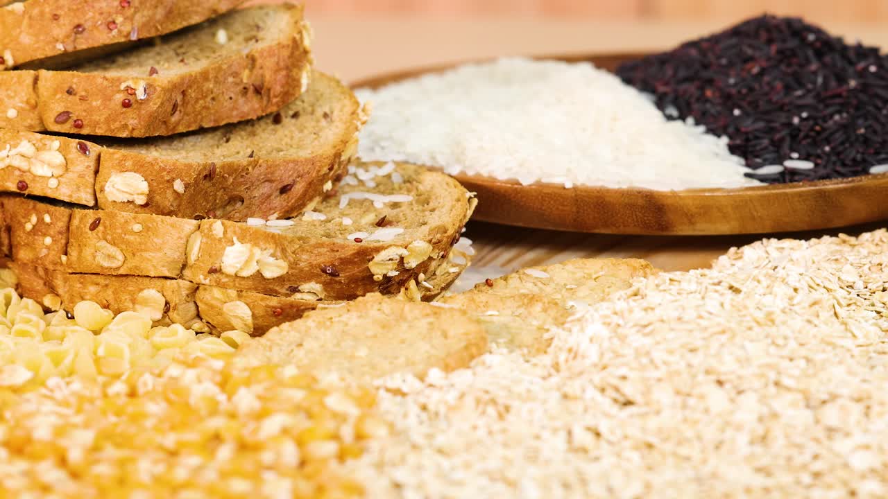 Slices of whole wheat bread with various grains and seeds on a wooden surface, captured in warm, natural lighting
