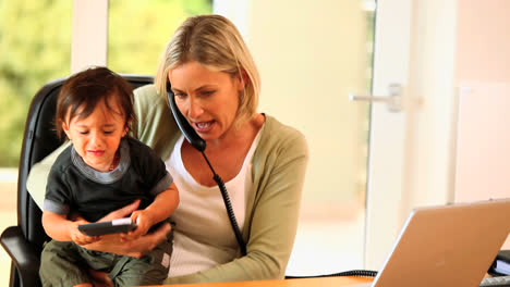 mother struggling with office work and restless baby