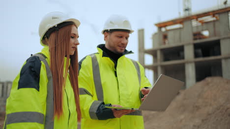 foreman and female building inspector are walking on construction area professional builders