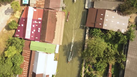 top down aerial view of boat sailing in floating market river canal, thailand countryside, near bangkok