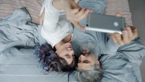 couple taking selfie in bed