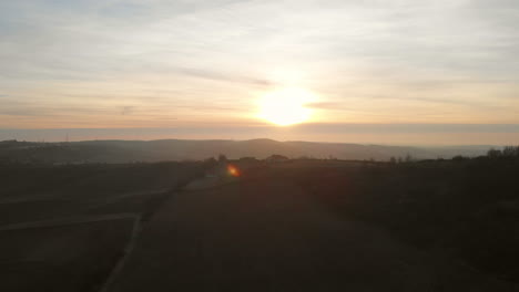 aerial countryside land with a farming house on the hill