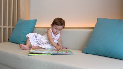 hermosa niña asiática aprendiendo colores y formas en un libro preescolar
