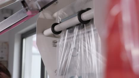 pulling plastic with laundry packing machine at laundry shop