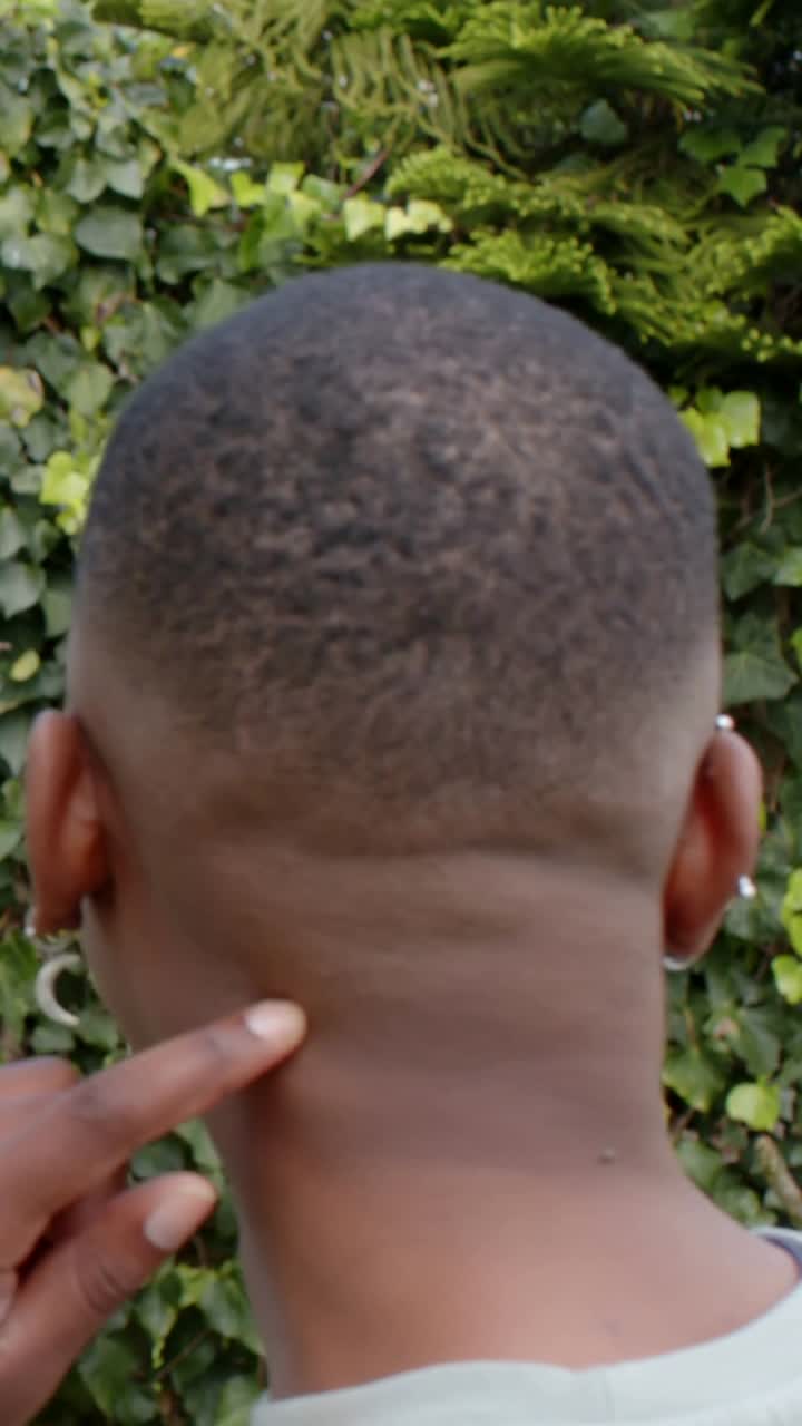 Vertical video: Leaning man in mustard top kissing cheek, hand tracing fade, revealing hoops by ivy