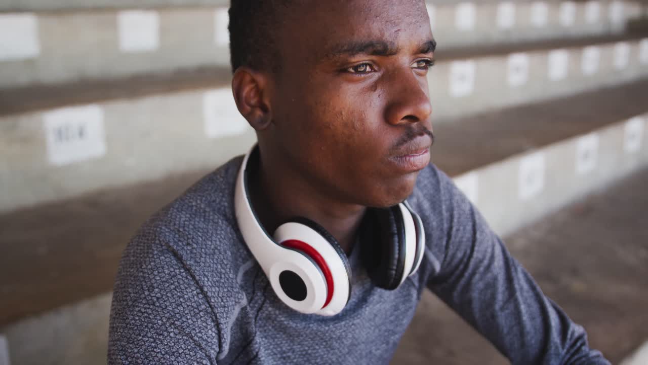 hombre de raza mixta discapacitado con piernas protésicas bebiendo agua y mirando hacia otro lado