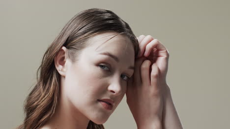 caucasian woman with brown hair touching face, copy space, slow motion