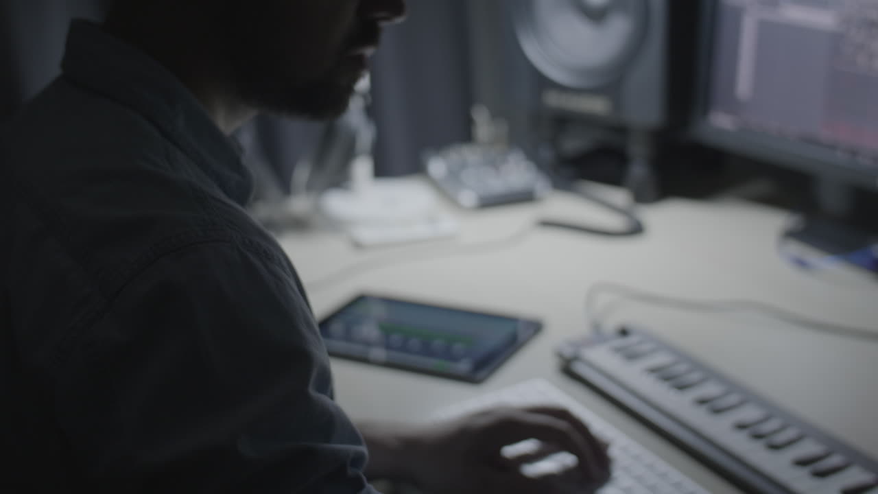 Producer, musician creating a beat on a drum pad in a recording studio