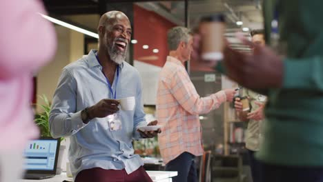 Happy-diverse-business-people-discussing-work-during-meeting-at-office