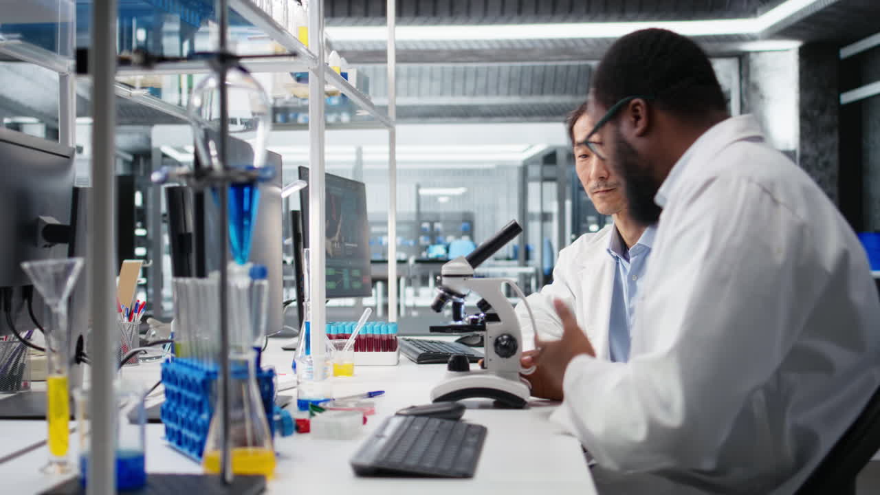Vertical video Team of multiethnic microbiologists working in lab with molecular microscope