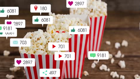 Animation-of-media-icons-over-boxes-of-popcorn