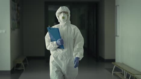 handheld video of worker in protective suit walking down the hall