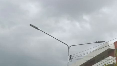 la luz de la calle se alza contra las nubes grises en tailandia