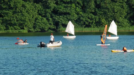 optimistas compitiendo en el lago azul durante la regata en kolbudy, condado de gdansk, polonia en verano