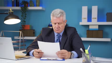 un hombre de negocios firmando papeles sintiéndose feliz.