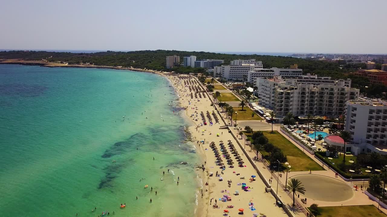 Cala major beach with turquoise waters and sunbathers, sunny day, aerial view
