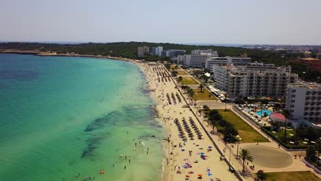 playa de cala mayor con aguas turquesas y bañistas de sol, día soleado, vista aérea