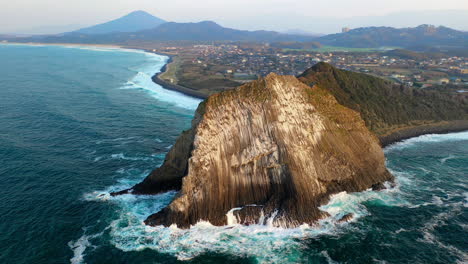 filmación cinematográfica de un dron giratorio de una gran roca en la costa de kyushu en japón