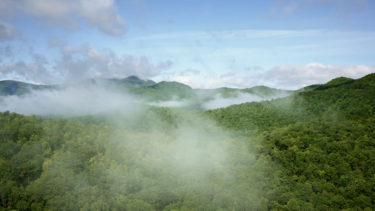 Cinematic aerial sweep across mist-filled Smoky Mountains, NC