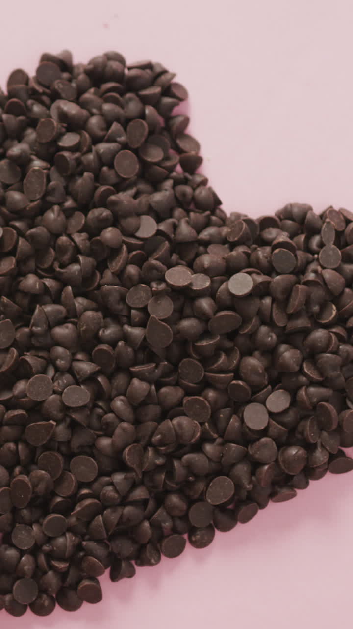 video de corazón formado con chispas de chocolate y espacio de copia sobre fondo rosa