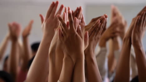 a crowd of people with hands raised in applause or celebration