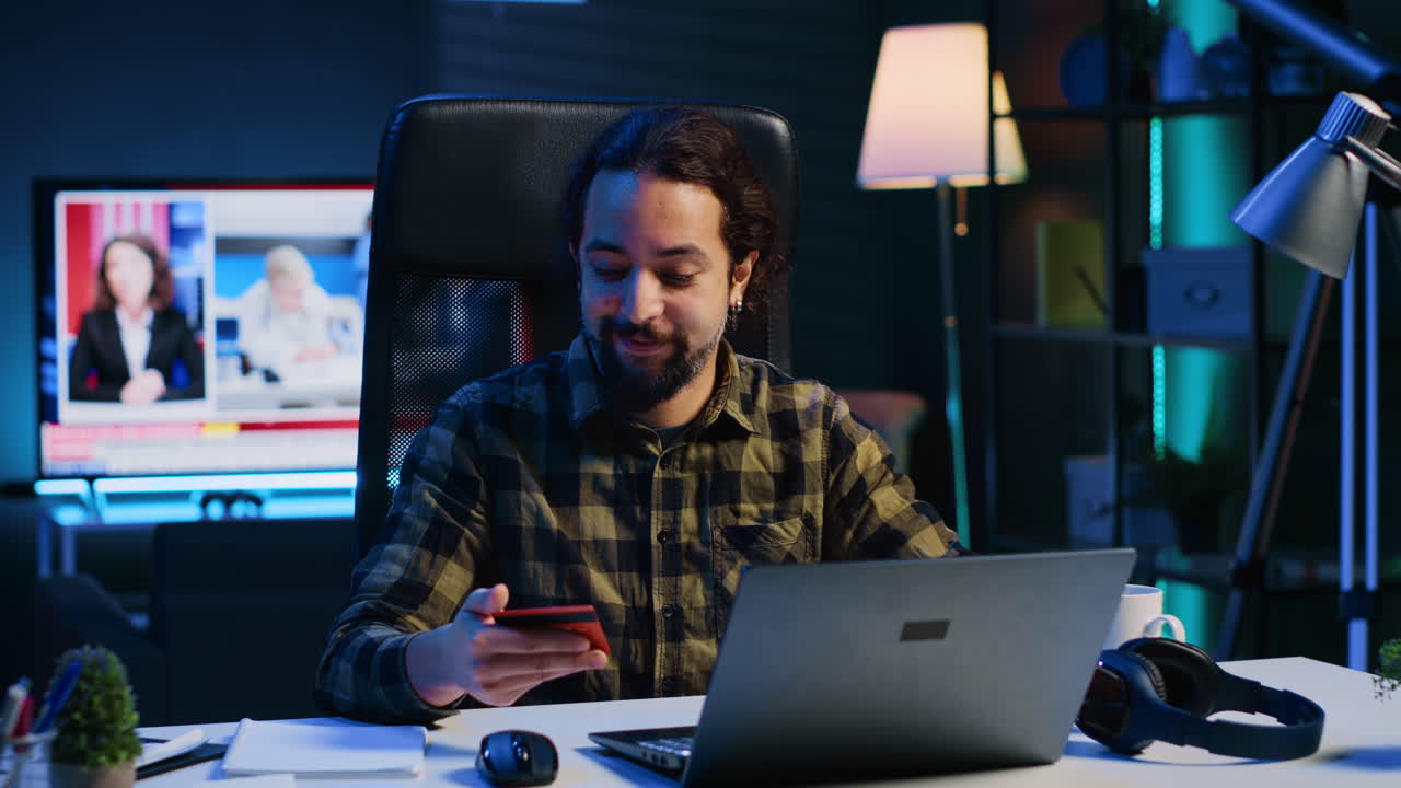 Happy man doing internet shopping, typing credit card information on laptop