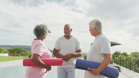 personas mayores felices y diversas practicando yoga en el jardín de una residencia de ancianos