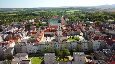 Aerial-view-of-Prudnik,-a-historical-town-in-southern-Poland,-town-hall-and-surrounding-historic-buildings-with-red-tiled-roofs