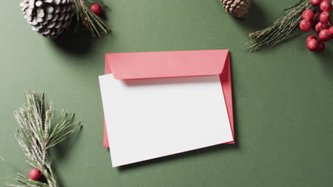 video of christmas decorations and white card with copy space on green background