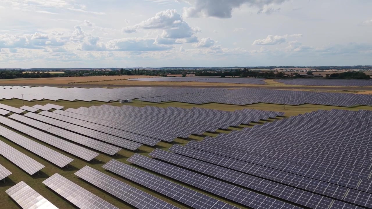 Ren vedvarende energi produceret af solpaneler arrangeret på en stor solrig mark om dagen for at forsyne hjem og virksomheder med strøm, hvor sollys omdannes til elektricitet for bæredygtig energi.