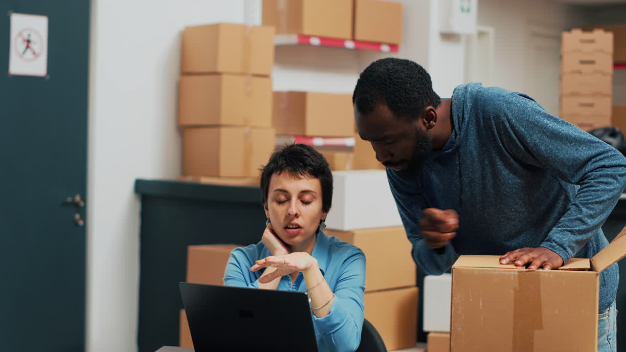 People working with boxes and laptop in a warehouse